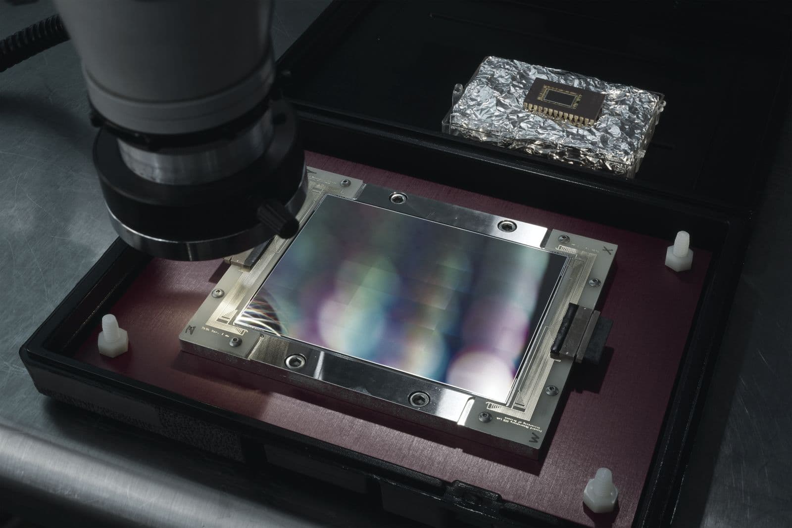 Objetivo de un microscopio de inspección sobre un sensor de imagen montado en su soporte