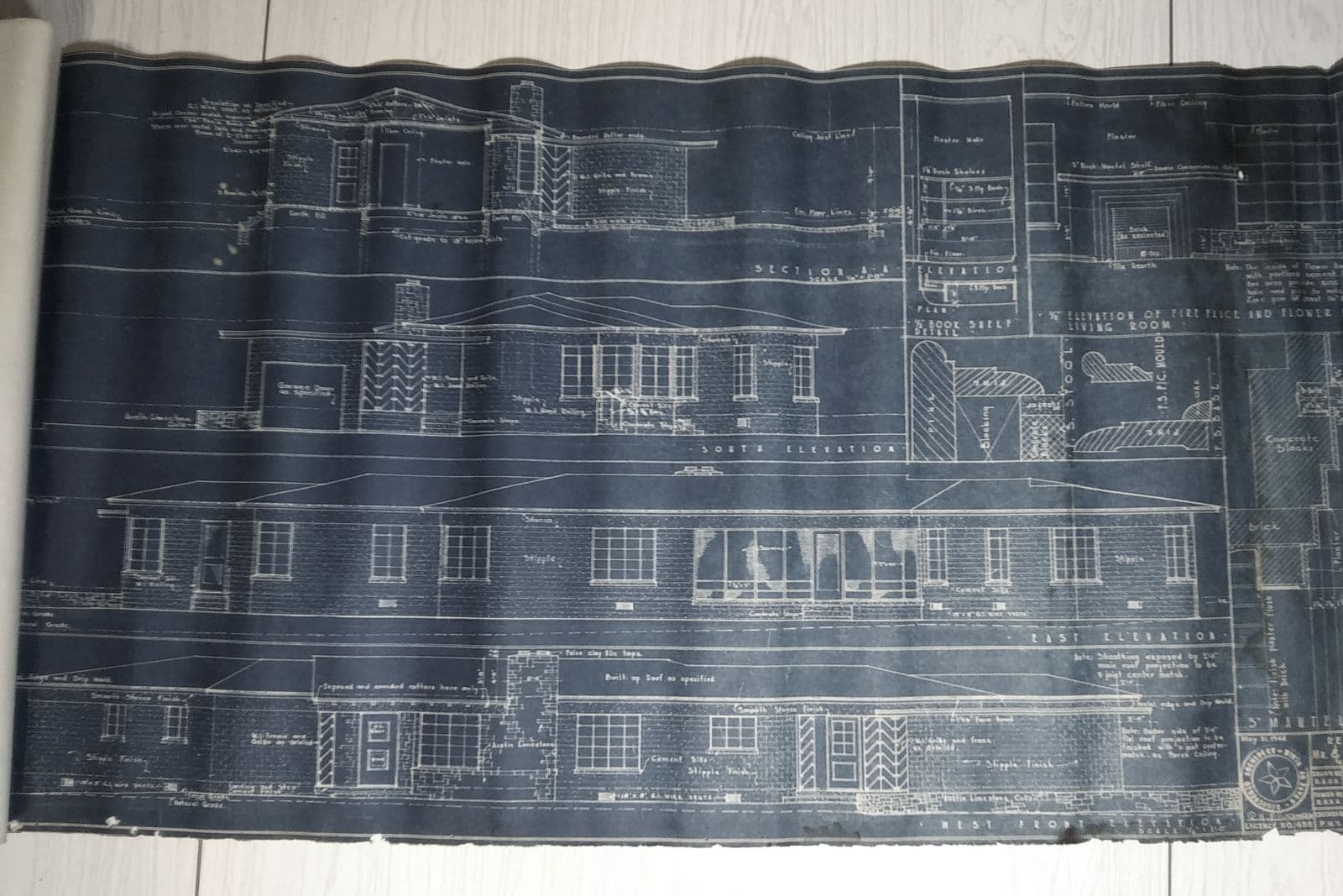 Plano de arquitectura en cianotipo desenrollado con alzados y secciones de un edificio