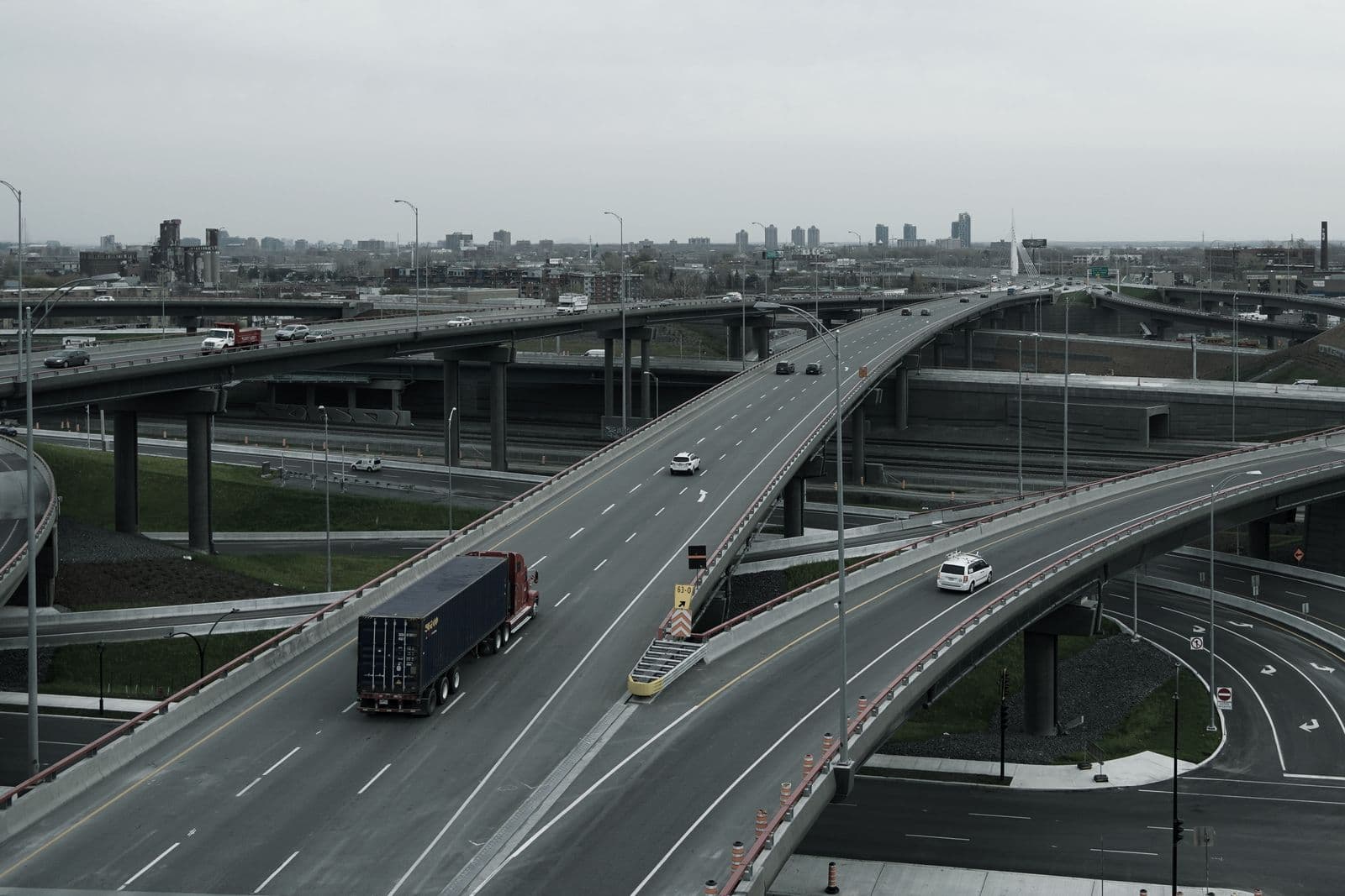 Camión con contenedor circulando por un enlace de autopistas elevado
